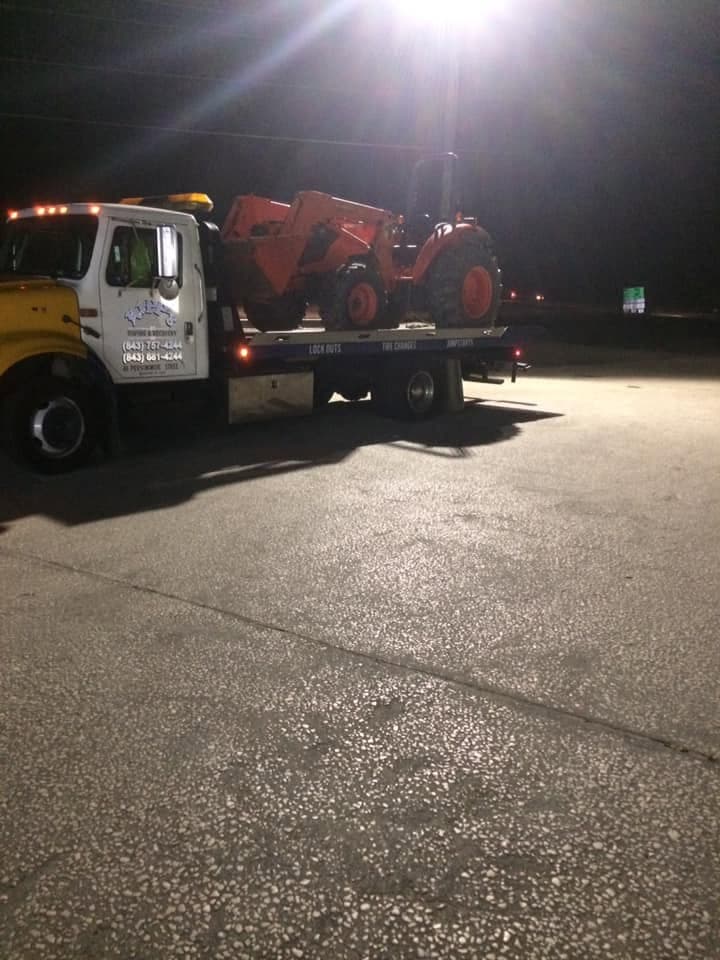 Operator in high-vis vest next to tow truck