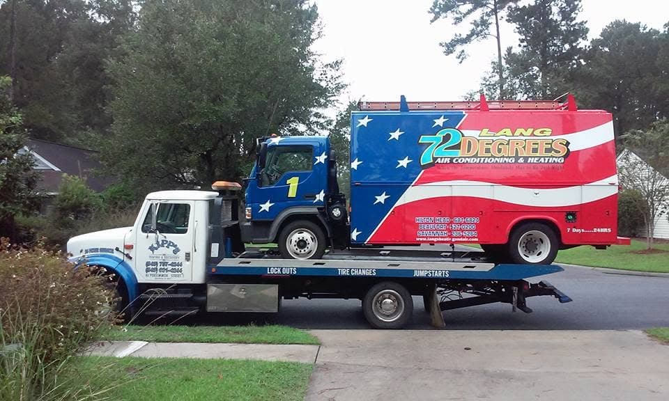 Kipp's flatbed towing an HVAC service truck with American flag wrap