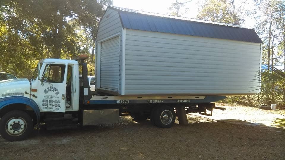 Tow truck transporting a storage shed