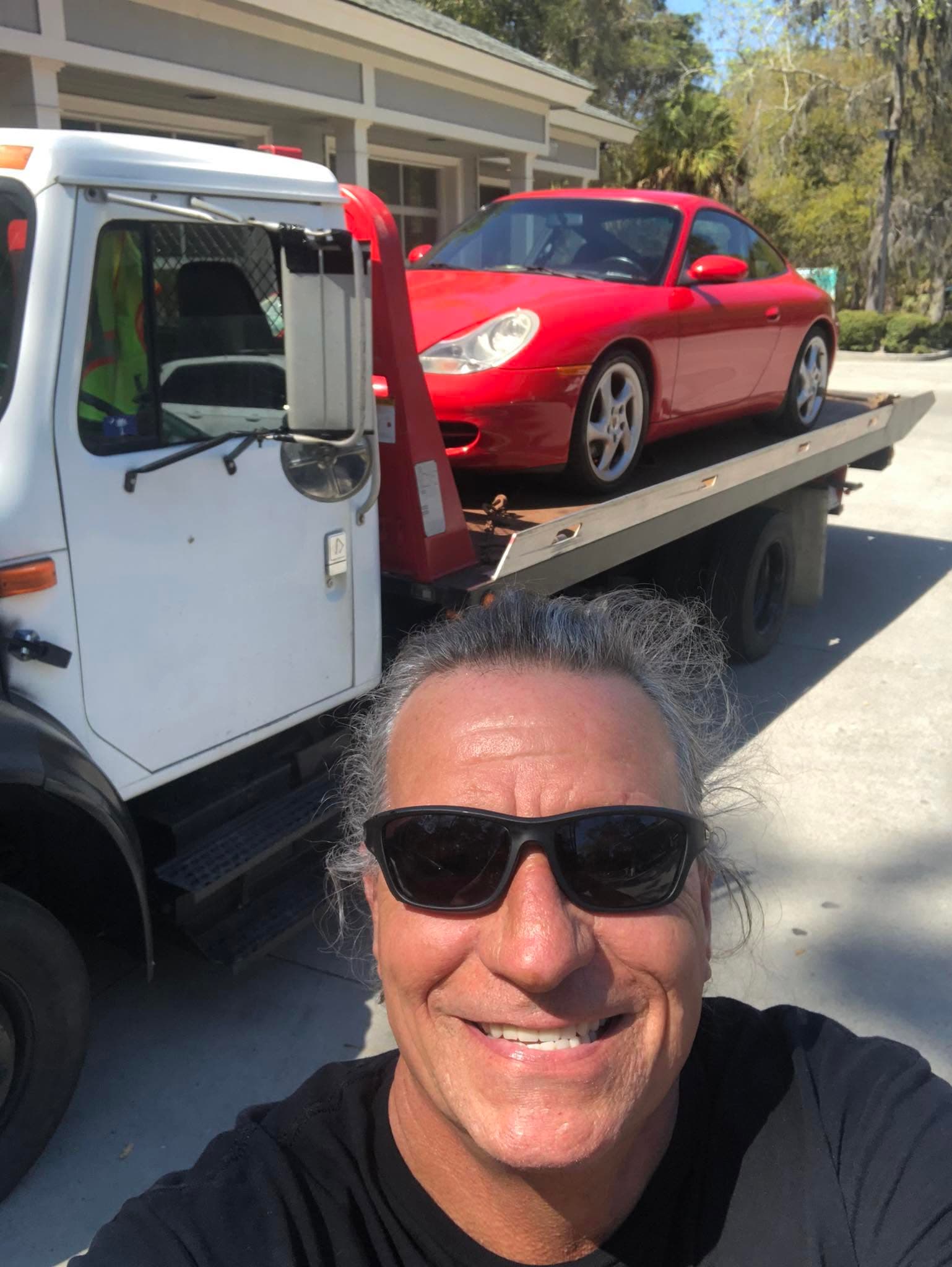 Tow truck carrying Paul Davis restoration trailer