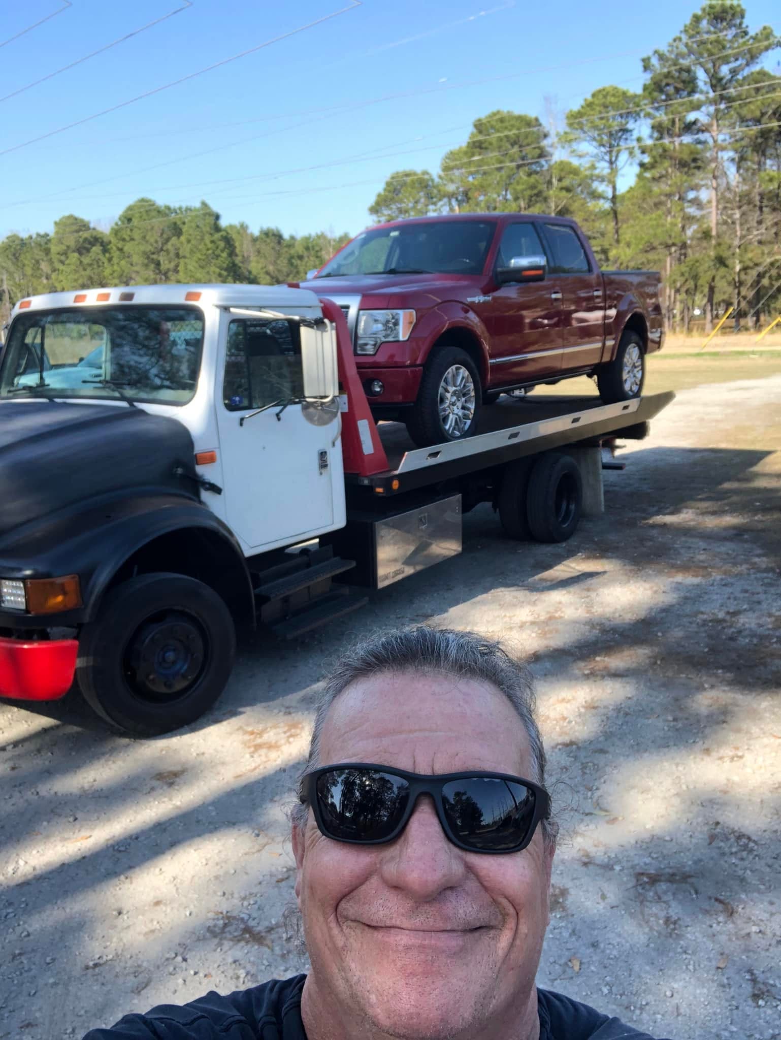 Tow truck carrying small shed with open door